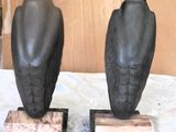 two statues of birds sitting on top of a table