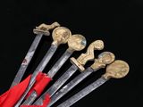 six swords with gold and red handles on a black background