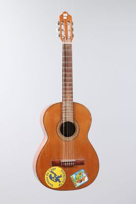 an image of a wooden guitar with a sticker on the back of it