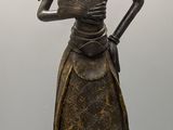 statue of a woman in a long dress holding a bird