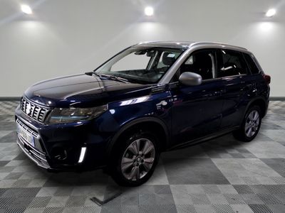 the blue suv is parked on a checkered floor in a garage