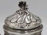 a silver tea pot with a lid on a table