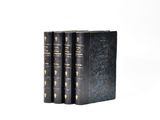 three black books with gold trims on them sitting on a white surface