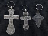 three silver crosses are displayed on a black surface