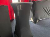 two speakers sitting on a stage in front of a red curtain