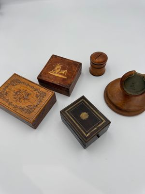 four small wooden boxes and a candle holder on a white surface