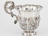 une coupe ancienne en argent munie d'une anse, sur fond blanc