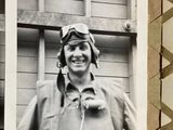 a black and white photo of a man wearing a pilot ' s hat