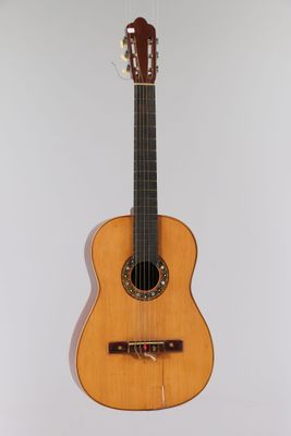 a close up of a guitar hanging on a wall