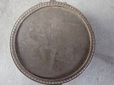 a silver coin with a picture of a man and a woman holding an umbrella