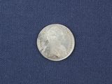 a close up of a silver coin on a blue cloth