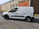 a small white van parked on the side of the road