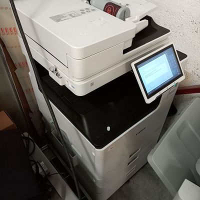 une pile d'imprimantes empilées les unes sur les autres dans une pièce