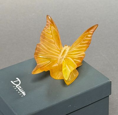 un papillon jaune posé sur une boîte noire