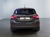 the back end of a grey car in a room with white walls