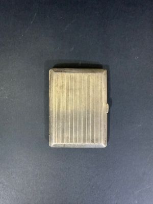 a small square metal object on a black surface
