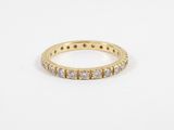 a yellow gold ring with white diamonds on a white background