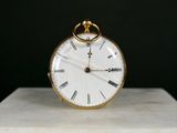 une horloge en or posée sur un bloc de marbre