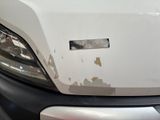 a white truck that has been damaged and is parked in a lot