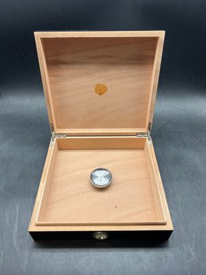 a wooden box with a watch inside of it on a table