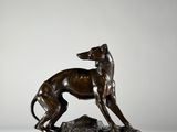 statue en bronze d'un chien sur un rocher sur fond blanc