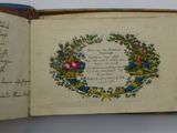 an open book with a picture of a wreath of flowers on it