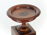 a wooden pedestal with a wooden bowl on top of it