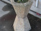 a concrete planter sitting on the sidewalk next to a building