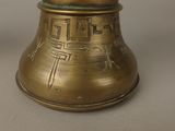 a gold bell with a cross on it sitting on a table