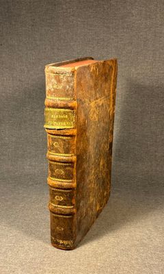 an old book sitting on top of a table next to a gray background