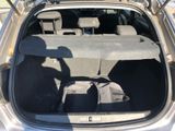 the back of a silver car with its trunk open and luggage in the trunk