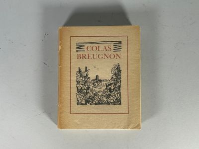 un vieux livre posé sur une table à côté d'un mur blanc