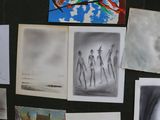 many drawings and pictures on the wall of a room