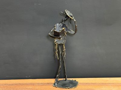 statue of a man with a hat on his head on a wooden table