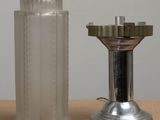 a silver candle that is next to a glass candle holder