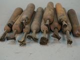 six old wooden baseball bats sitting on top of a white table