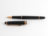 two black and gold fountain pens sitting on top of a white surface