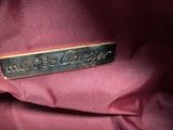 a close up of a pink purse with a gold label on it