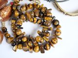 a bracelet with a tiger eye bead on it next to a pair of scissors