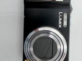 a black camera sitting on a table with a pen in it
