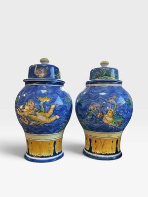 une paire de vases bleus et jaunes ornés de motifs sur fond blanc
