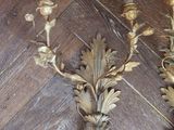 two gold candles that are on a wooden floor