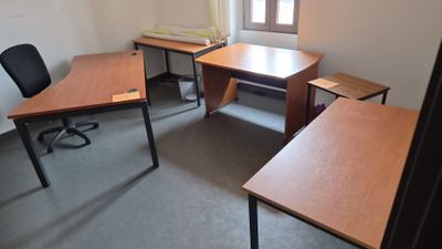 une photo d'un bureau vide avec des bureaux et des chaises