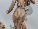 a statue of a woman and a clock on a table