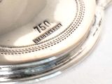 a close up of a silver plate with a clock on it