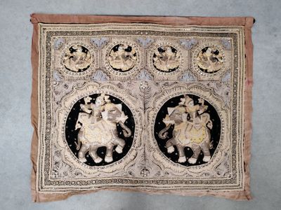 une image représentant un morceau de tissu sur lequel figurent deux femmes et un homme