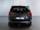 the back end of a small grey van parked in a garage