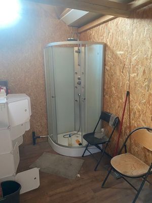 une salle de bains équipée d'une douche et d'une chaise