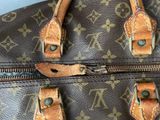 a close up of a louis vuitton bag with three handles