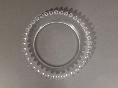 a glass plate with beads on it on a table